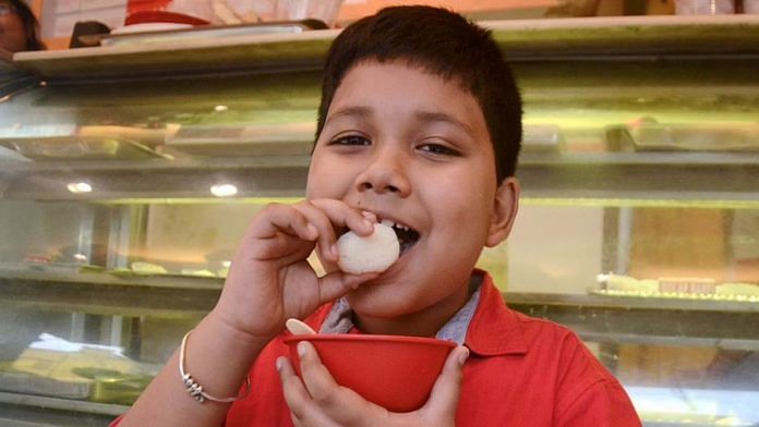 A boy eating rasgulla at a sweets shop in Kolkata | PTI Photo