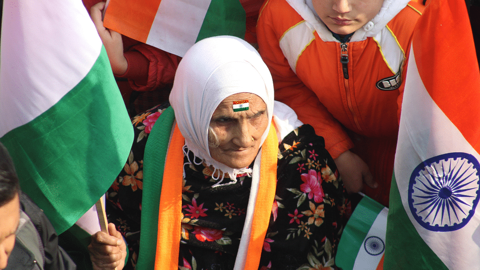 An elderly woman at a protest site with the Indian national flag or the Tiranga | Pexels