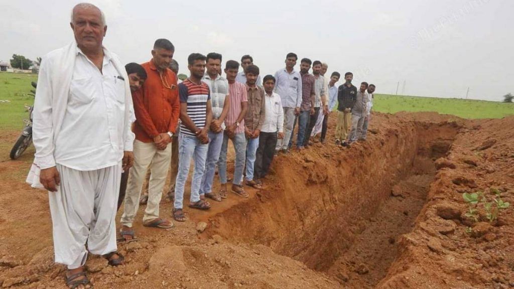 Sarpanch Trikam Ramji Varchand with local residents next to a burial spot for cows in Ratnal | Praveen Jain | ThePrint