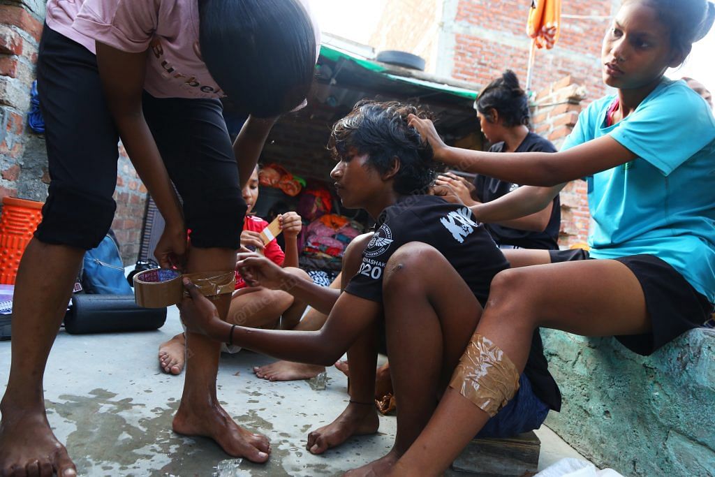 Girls wrap ice using brown tape | Photo: Manisha Mondal | ThePrint