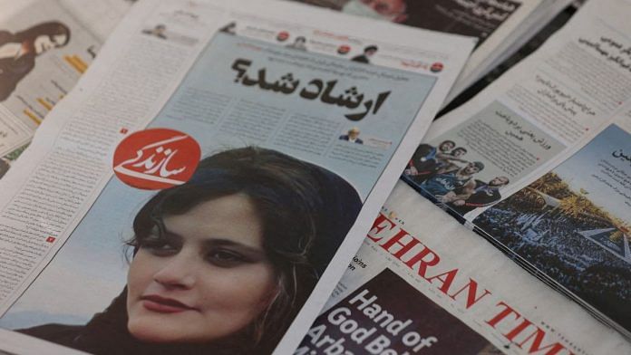 A newspaper with a cover picture of Mahsa Amini, a woman who died after being arrested by Iranian morality police is seen in Tehran | Majid Asgaripour/WANA (West Asia News Agency) via Reuters