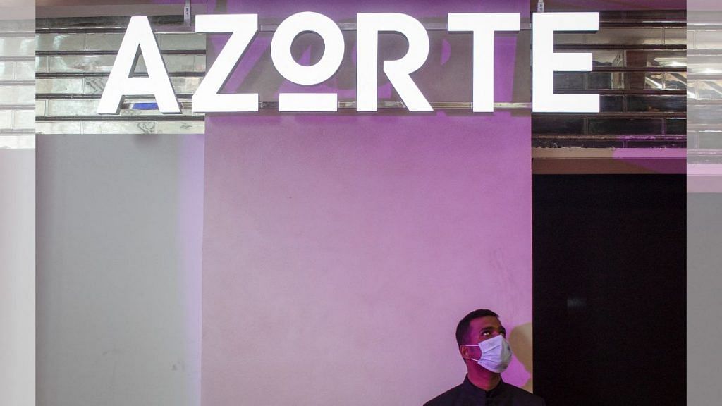 An employee wearing a face mask stands outside the Azorte, a fashion and lifestyle store of Reliance Industries, during its launch in Bengaluru, on 29 September 2022 | Reuters
