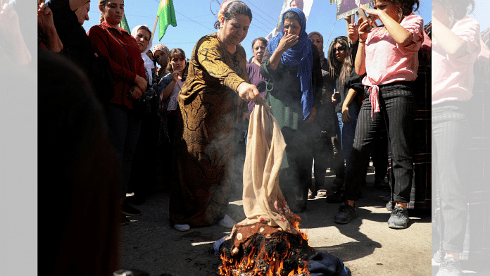 File photo of women burning headscarves during a protest over the death of 22-year-old Kurdish woman Mahsa Amini in Iran, in the Kurdish-controlled city of Qamishli, northeastern Syria September 26, 2022/ REUTERS