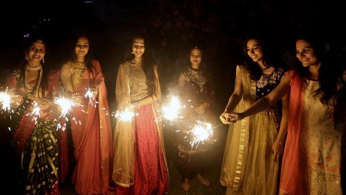 Women celebrate by lighting phuljari crackers on the eve of the Diwali festival | ANI