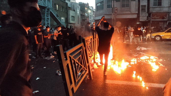 People light a fire during a protest over the death of Mahsa Amini, a woman who died after being arrested by the Islamic republic's 