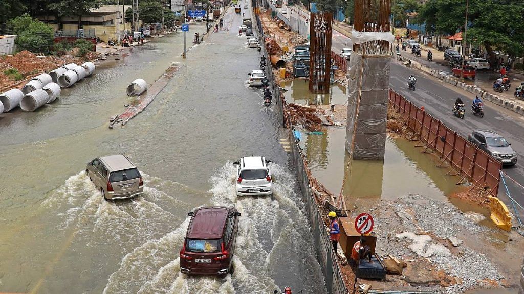 Commuters wade through a waterlogged Bengaluru street | ANI