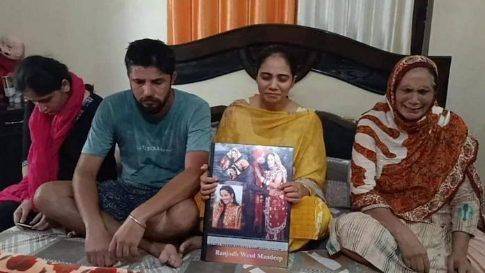 Mandeep Kaur's family hold a collage of photos from her wedding | change.org