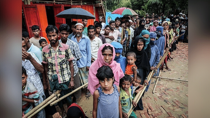 Refugees standing in a queue at a refugee camp | Commons