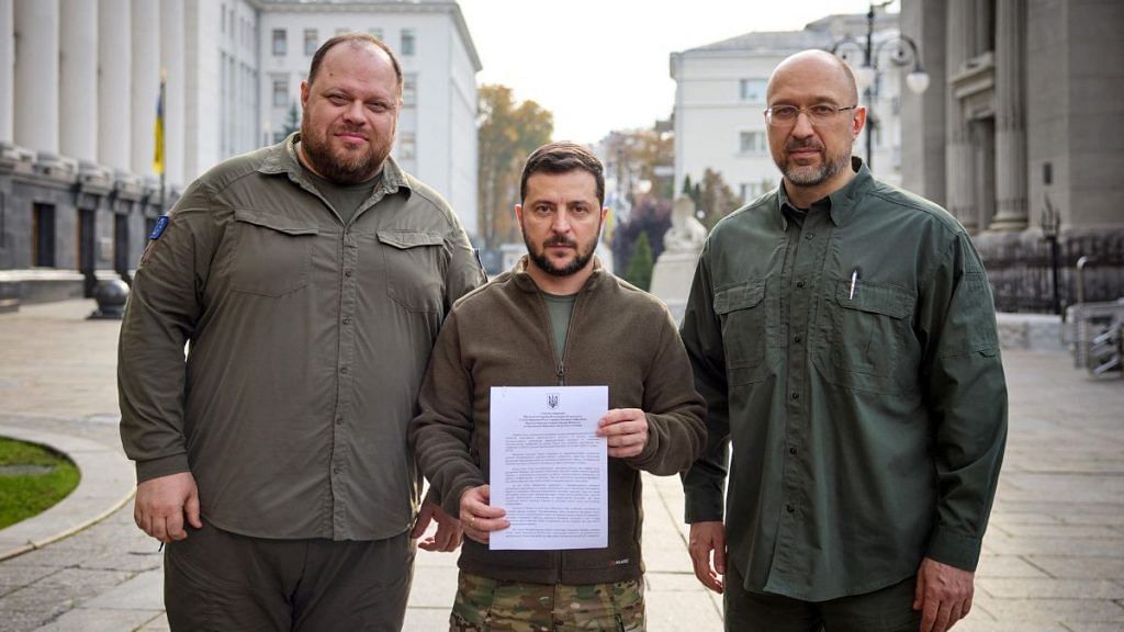 Ukraine's President Volodymyr Zelenskyy, PM Denys Shmyhal and Parliament Speaker Ruslan Stefanchuk pose with a request for fast-track membership in the NATO military alliance, in Kyiv, on 30 September 2022 | Ukrainian Presidential Press Service/Handout via Reuters