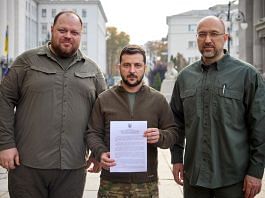 Ukraine's President Volodymyr Zelenskyy, PM Denys Shmyhal and Parliament Speaker Ruslan Stefanchuk pose with a request for fast-track membership in the NATO military alliance, in Kyiv, on 30 September 2022 | Ukrainian Presidential Press Service/Handout via Reuters