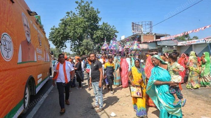 Women walk pass a van of Gaurav Yatra at a pit stop | Praveen Jain | ThePrint