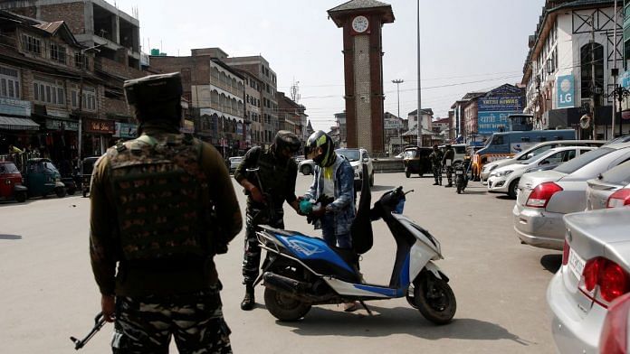 Indian Central Reserve Police Force (CRPF) personnel check the bags of a scooterist as part of security checking in Srinagar | Reuters/Danish Ismail