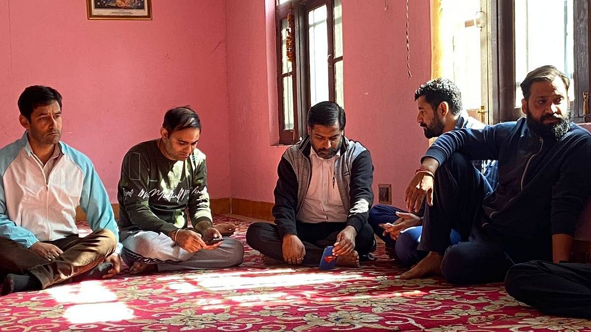 Some people assembled at a house inside Some people sitting outside Sheikhpora Pandit Colony in Budgam | Ananya Bharadwaj | ThePrint