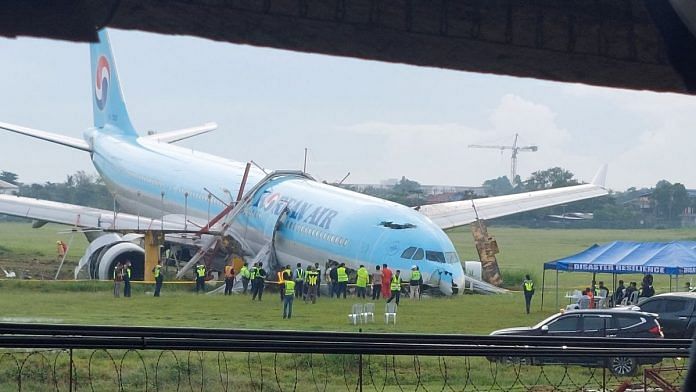 Response crews gather around a Korean Air Airbus A330 widebody flying from Seoul to Cebu, which tried to land twice in poor weather before it overran the runway on the third attempt on Sunday, in Lapu-Lapu City, Cebu, Philippines 24 October, 2022 in this picture obtained from social media | Randyl Dungog/Reuters