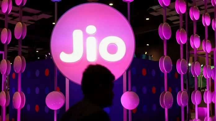 A man walks across the LED board showing the logo of Jio at Pragati Maidan in New Delhi | Reuters file photo