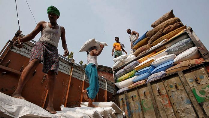 A labourer carries a sack filled with sugar to load it onto a supply truck at a wholesale market in Kolkata | Reuters file photo