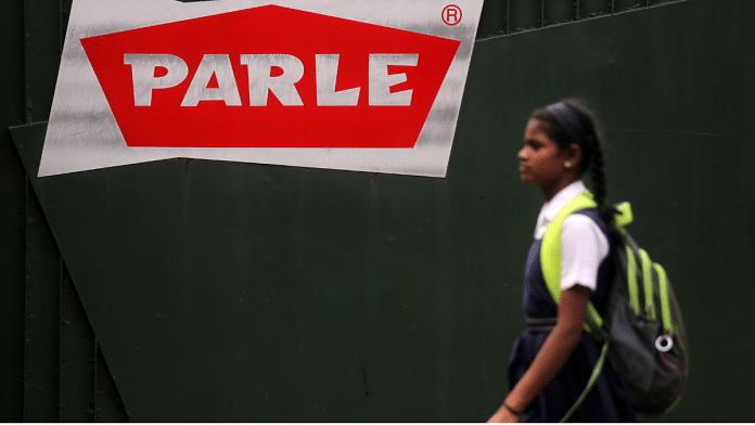 A girl walks past the logo of Parle Products painted on a gate of company's office in Mumbai, India, August 19 2021. Reuters/Francis Mascarenhas/File Photo