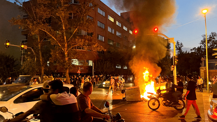 A police motorcycle burns during a protest over the death of Mahsa Amini in Tehran | WANA (West Asia News Agency) via Reuters//File Photo