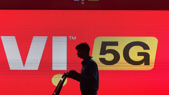 A man walks across the LED display board showing the logo of Vodafone-Idea at the ongoing India Mobile Congress 2022, at Pragati Maidan, in New Delhi, India, 3 October 2022. Reuters/Anushree Fadnavis/File Photo