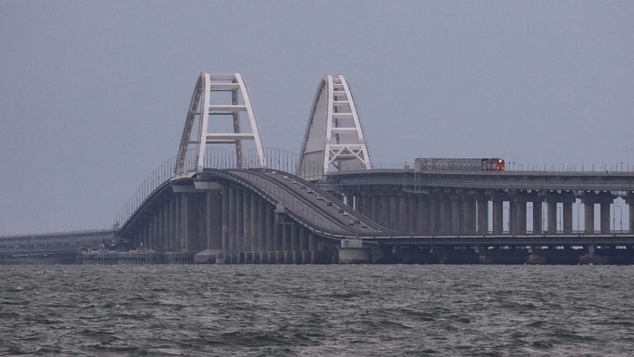 A passenger train and cars drive on the Kerch bridge, after an explosion destroyed part of it | Reuters/Alexey Pavlishak