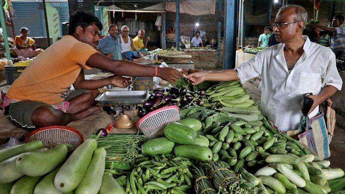 File photo of Nikhil Kumar Mondal, 65, a retired school headmaster, buys vegetables from a vendor at a market on the outskirts of Kolkata, India, 20 May, 2022. | Reuters