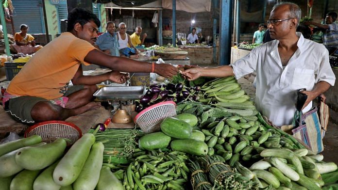 File photo of Nikhil Kumar Mondal, 65, a retired school headmaster, buying vegetables from a vendor at a market on the outskirts of Kolkata, India, 20 May, 2022 | Reuters