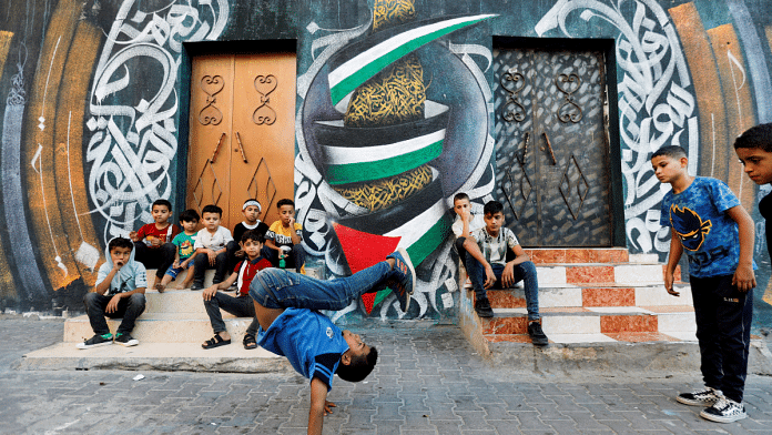 A Palestinian boy performs breakdancing on the street in Nusseirat refugee camp in central Gaza Strip, 14 October 2022. Reuters/Ibraheem Abu Mustafa