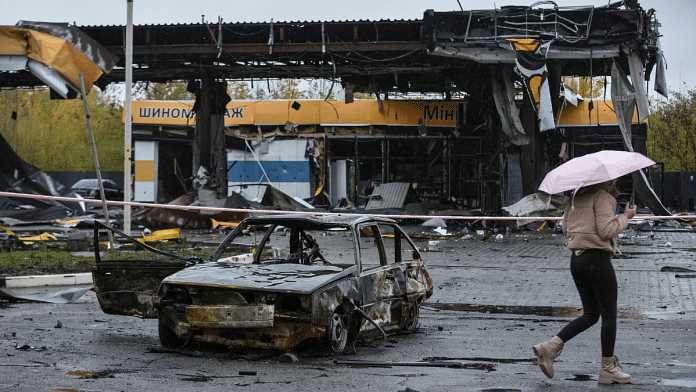 A woman passes by a gas station destroyed by yesterday's Russian military strike, as Russia's attack on Ukraine continues, in Dnipro 26 October, 2022. Reuters/Mykola Synelnykov