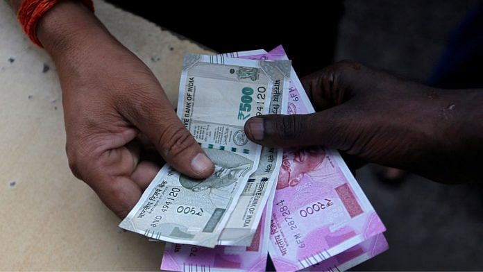 File photo of a customer handing currency notes to an attendant at a fuel station in Mumbai, 13 August, 2018. | Reuters