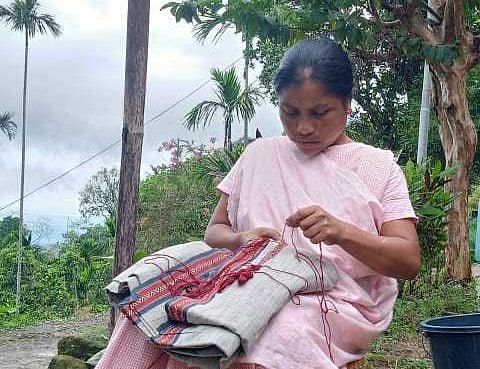 Victory Synrem, one of the three remaining women who know the Khneng craft, stitching embroidery pattern | Photo: NESFAS