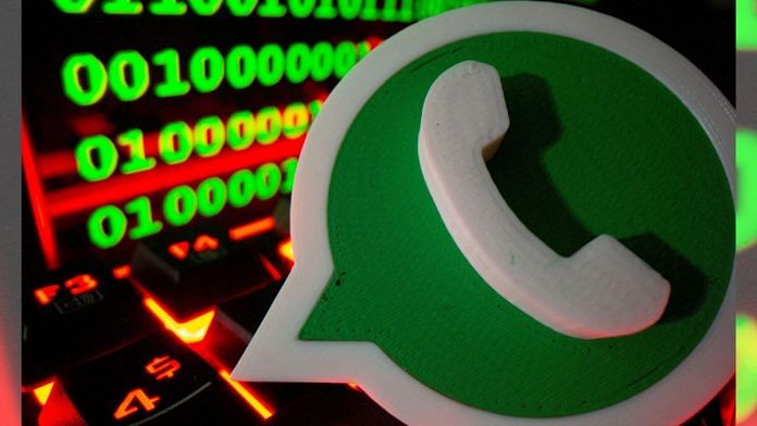 A 3D printed Whatsapp logo is pictured on a keyboard in front of binary code | Illustration by Dado Ruvic/Reuters