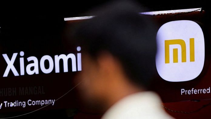 A man walks past a logo of Xiaomi, a Chinese manufacturer of consumer electronics, outside a shop in Mumbai | Reuters file photo