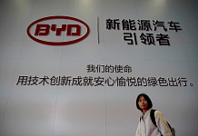 FILE PHOTO: A woman walks past a BYD sign at the second media day for the Shanghai auto show in Shanghai, China April 17, 2019. REUTERS/Aly Song