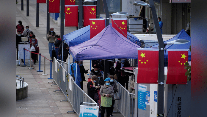 People line up to get tested for the coronavirus disease (COVID-19) at a nucleic acid testing site, following the coronavirus disease (COVID-19) outbreak, in Shanghai, China, October 10, 2022. REUTERS/Aly Song