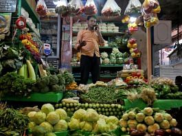 A vegetable vendor speaks on his mobile phone at a retail market area in Kolkata | Reuters file photo