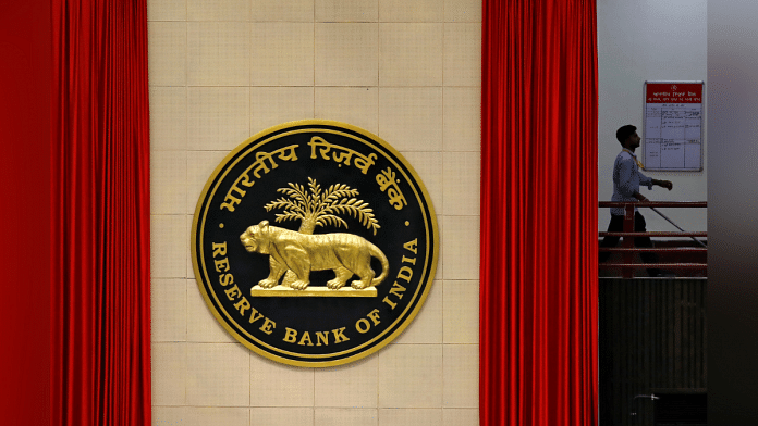 A worker walks past the logo of Reserve Bank of India (RBI) inside its office in New Delhi, India | Photo: Reuters FIle Photo/Anushree Fadnavis
