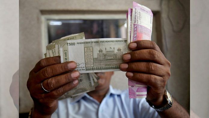 A cashier checks Indian rupee notes inside a room at a fuel station in Ahmedabad | Reuters file image