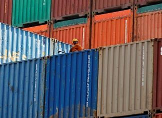A worker sits on a ship carrying containers at Mundra Port in the western Indian state of Gujarat | Reuters/Amit Dave/File Photo