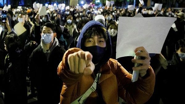 People hold white sheets of paper in protest over COVID-19 restrictions, after a vigil for the victims of a fire in Urumqi, in Beijing, China, November 27 | Photo: Reuters