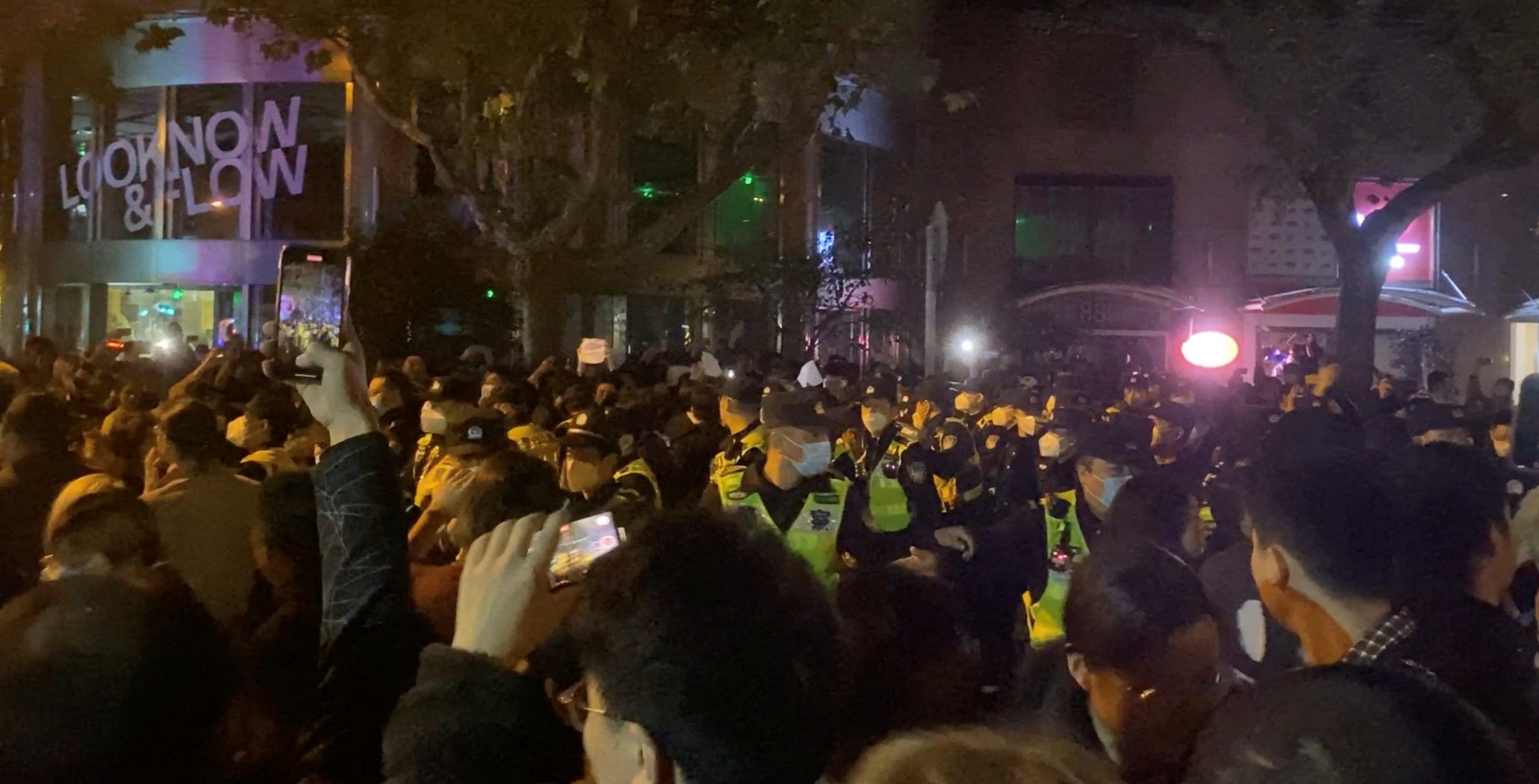 Protest against coronavirus disease (COVID-19) curbs, in Shanghai Police officers drive people away during a protest against Covid curbs in Shanghai, on 27 November 2022 | Photo: screen grab obtained from a social media video via REUTERS