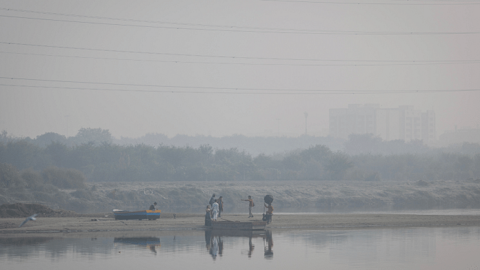 A couple poses during a pre-wedding photo on the banks of Yamuna river on a smoggy morning in the old quarters of Delhi, India 2 November, 2022. Reuters/Adnan Abidi/File Photo