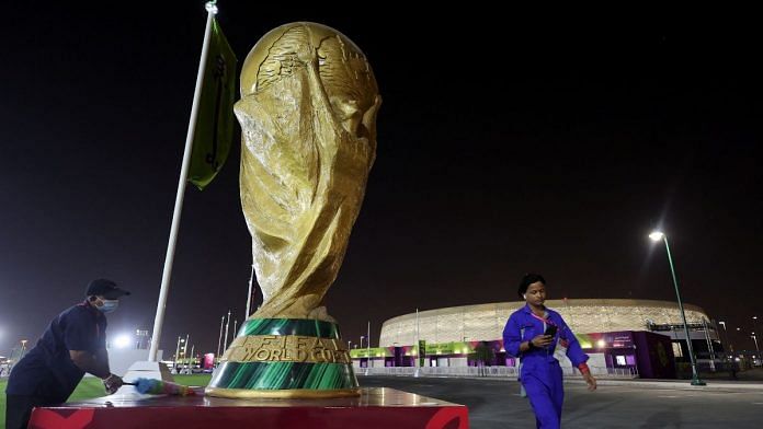 A worker cleans a sculpture of the World Cup trophy in front of Al Thumama Stadium ahead of the World Cup soccer tournament in Doha, Qatar 8 November, 2022 | Reuters