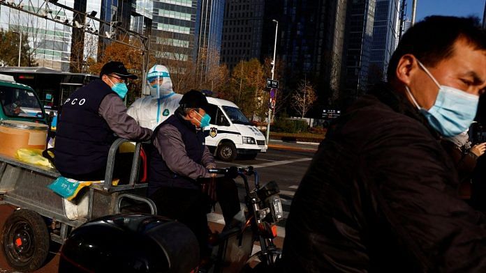 A worker in a protective suit seen on a street during morning rush hour, following the outbreak of the coronavirus disease (COVID-19), in Chaoyang District, Beijing, China 21 November, 2022 | Reuters