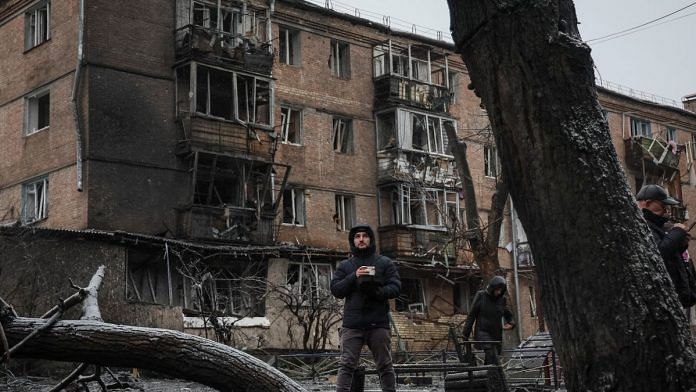 A local resident stands with a free hot food near a residential building destroyed by a Russian missile attack, in the town of Vyshhorod, near Kyiv, Ukraine on 24 November, 2022 | Reuters