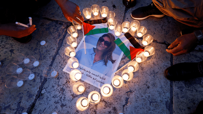 People light candles during a vigil in memory of Al Jazeera journalist Shireen Abu Akleh | Reuters File Photo/Mussa Qawasma