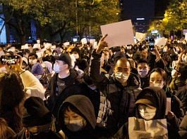 People hold white sheets of paper in protest of Covid restrictions in Beijing, on 27 November 2022 | Reuters/Thomas Peter