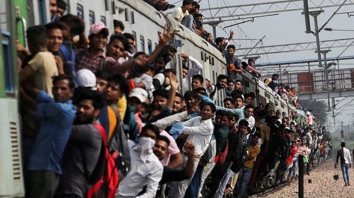 People cling on to a crowded train as it leaves a railway station in Ghaziabad | Reuters file photo