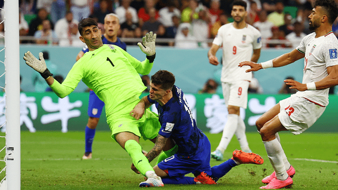 Christian Pulisic of the U.S. collides with Iran's Alireza Beiranvand after he scores their first goal | Reuters Photo/Kai Pfaffenbach