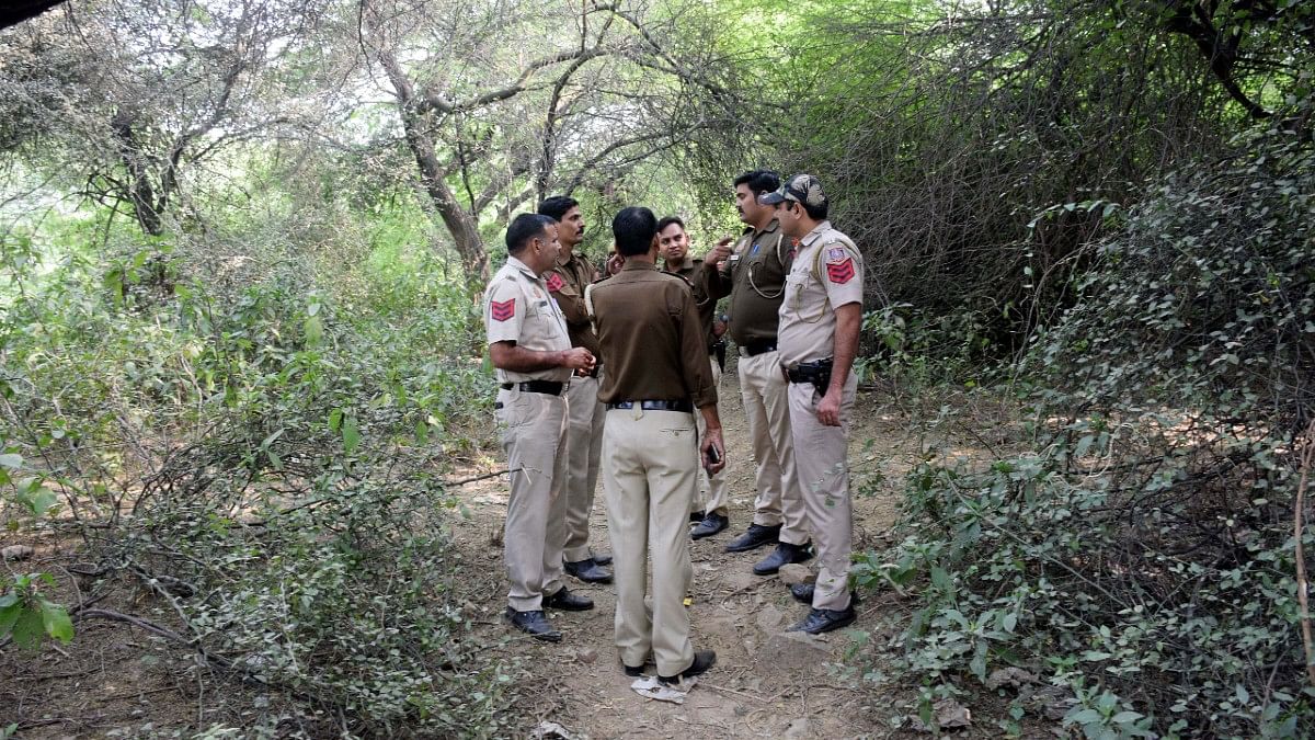 Police personnel at jungle area during a search Tuesday to locate body parts of the victim | ANI