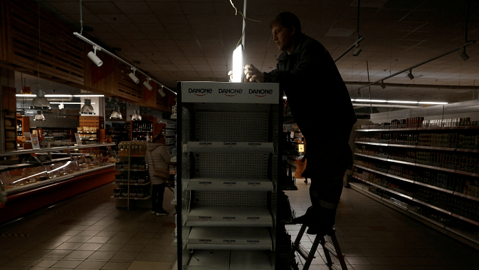 A supermarket worker installs a light powered by generator as Kharkiv suffers an electricity outage amid Russia's attack on Ukraine | Reuters File Photo/Clodagh Kilcoyne